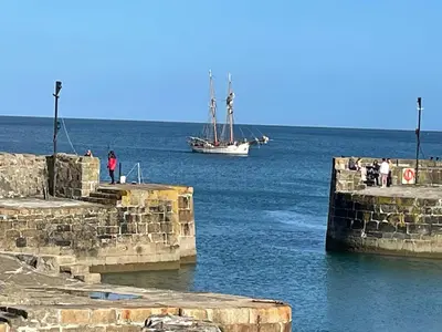 a boat in the water with people on the dock at The Potting Shed in St Austell