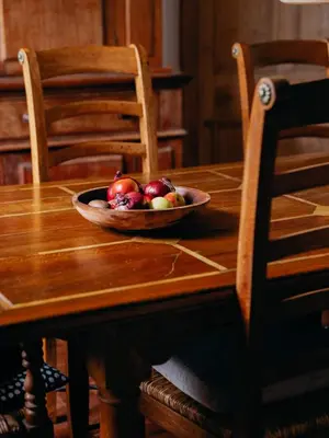 a bowl of fruit sitting on a wooden table at Enchanted Rose Garden House in Falmouth