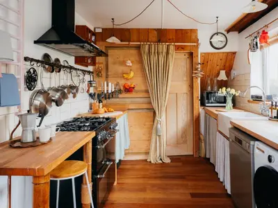 a kitchen with wooden walls and wooden flooring at Enchanted Rose Garden House in Falmouth