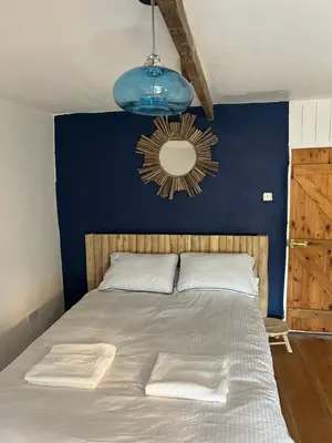 a bedroom with a large bed with a blue wall at The Cottage St Kew in Port Isaac