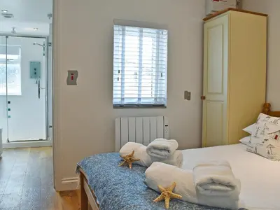 a bedroom with a bed with towels and starfish on it at Trenpeskador - Uk39442 in Saint Columb Minor
