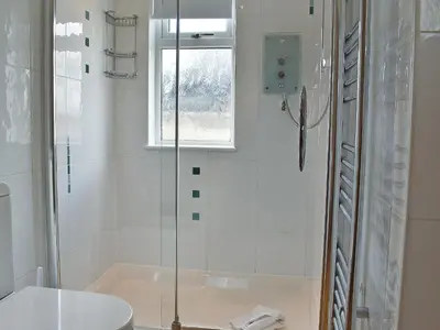 a bathroom with a shower and a toilet and a window at Trenpeskador - Uk39442 in Saint Columb Minor