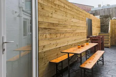 a wooden wall with a wooden table and benches at Sea View, Newquay Spacious house in Newquay