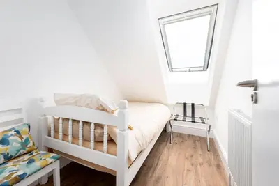 a white bedroom with a bunk bed and a window at Sea View, Newquay Spacious house in Newquay