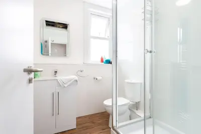 a white bathroom with a toilet and a shower at Sea View, Newquay Spacious house in Newquay