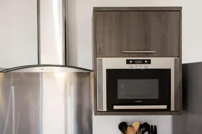 a kitchen with a microwave and a stove at Sea View, Newquay Spacious house in Newquay
