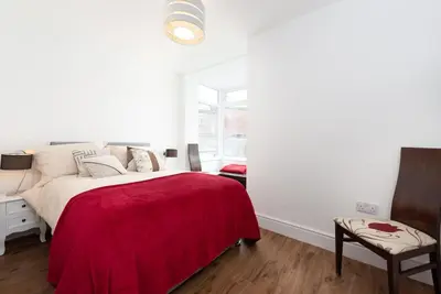 a bedroom with a bed with a red blanket at Sea View, Newquay Spacious house in Newquay
