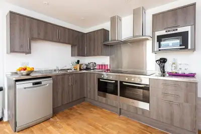 a kitchen with wooden cabinets and stainless steel appliances at Sea View, Newquay Spacious house in Newquay