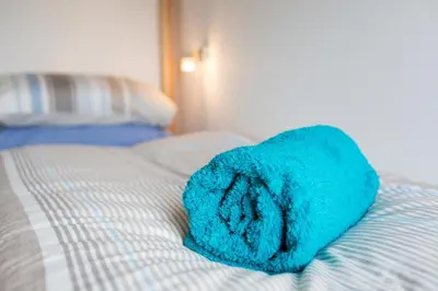 a blue towel sitting on top of a bed at Sea View, Newquay Spacious house in Newquay