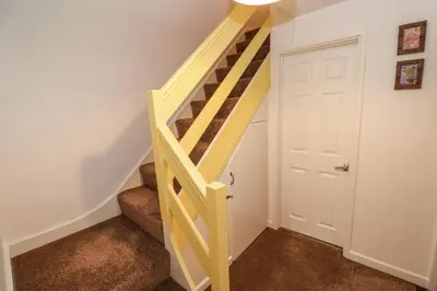 a wooden staircase in a room with a white door at Flat 6 in Falmouth