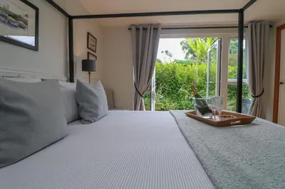 a bedroom with a large bed with a window at Chi Lowarth in Helston