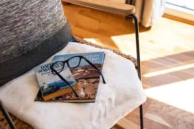 a pile of books sitting on top of a chair at Chi Lowarth in Helston