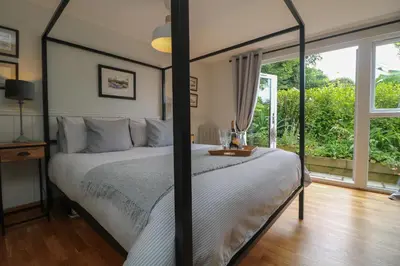 a bedroom with a canopy bed with a window at Chi Lowarth in Helston