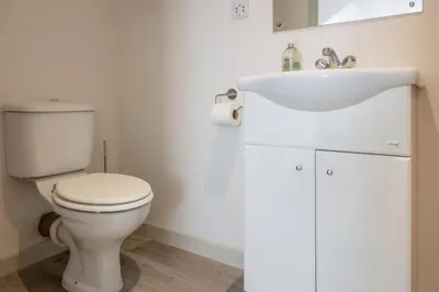 a bathroom with a white toilet and a sink at Macdonald's Farm in Saint Ervan