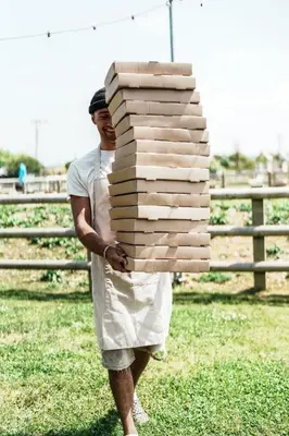 a man is carrying a stack of books at Macdonald's Farm in Saint Ervan