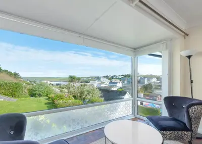 a room with a large window with chairs and a table at Beach Haven in Wadebridge