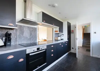 a kitchen with blue cabinets and a counter top at Beach Haven in Wadebridge