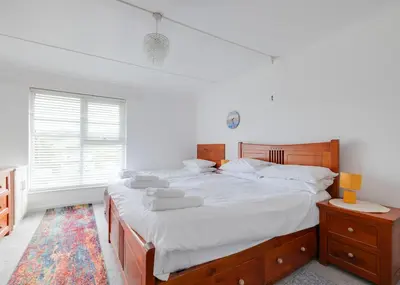 a bedroom with a large bed and a window at Beach Haven in Wadebridge