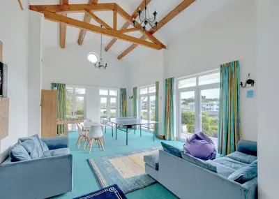 a living room with two blue couches and a table at Beach Haven in Wadebridge