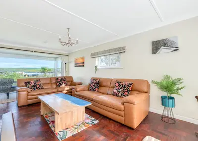 a living room with two brown leather couches and a table at Beach Haven in Wadebridge