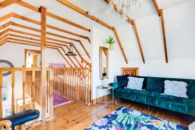 a living room with a green couch and wooden floors at Baywatch Sands in Wadebridge