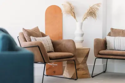 a pair of chairs and a surfboard in a room at Luxury Family Apartment with sea views in Newquay