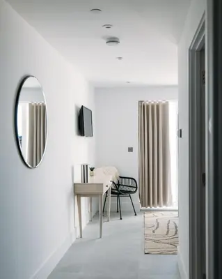 a living room with a mirror and a table at Luxury Family Apartment with sea views in Newquay
