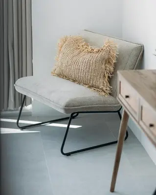 a chair with a throw pillow sitting next to a desk at Luxury Family Apartment with sea views in Newquay