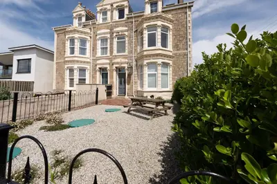 a house with a bench in front of it at Cormorant Views, Marazion in Marazion