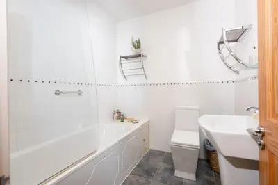 a bathroom with a tub and a toilet and a sink at Cormorant Views, Marazion in Marazion