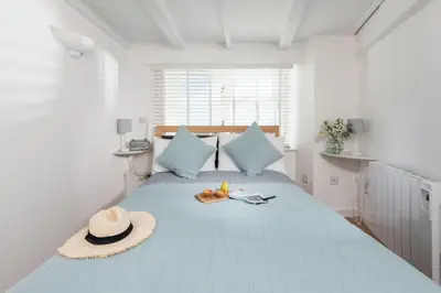 a bedroom with a bed with a hat and shoes on it at Stunning Sea Views, Wi-Fi, Pet Friendly in Marazion