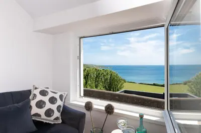 a living room with a window with a view of the ocean at Stunning Sea Views, Wi-Fi, Pet Friendly in Marazion