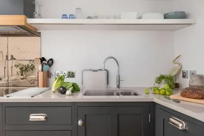 a kitchen with a sink and fruits and vegetables on the counter at Stunning Sea Views, Wi-Fi, Pet Friendly in Marazion