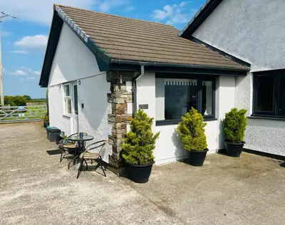 a house with a table and chairs and potted plants at West Moor View Apartment in Launceston