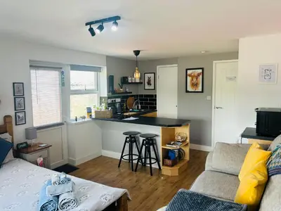 a living room with a couch and a kitchen at West Moor View Apartment in Launceston