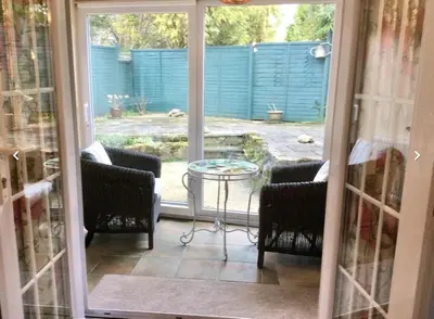 a screened in porch with a table and chairs at Lovely Cornish cottage in small village setting in Saint Hilary