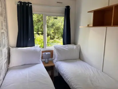 two beds in a room with a window at Cornish coastal retreats- 74 newquay view in Porth
