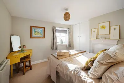 a bedroom with a bed and a desk and a mirror at Beautiful 3 bedroom cottage in the heart of Looe in Looe