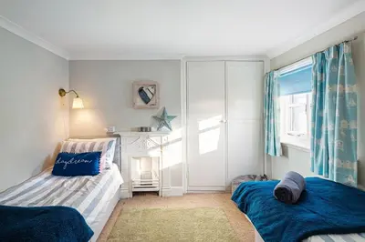 a bedroom with two beds and a window at Beautiful 3 bedroom cottage in the heart of Looe in Looe
