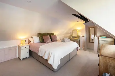 a bedroom with a large bed in a attic at Beautiful 3 bedroom cottage in the heart of Looe in Looe
