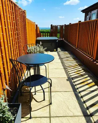 a table and chairs on a patio with a fence at The Beehive -Stunning Views - Hot Tub - Romantic in Launceston