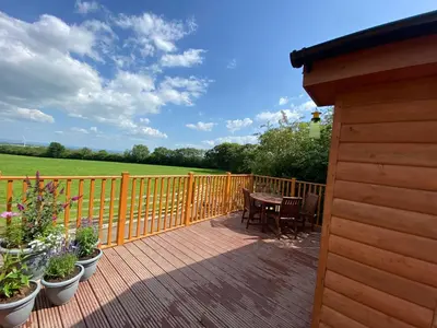 a wooden deck with a table and chairs and a fence at The Beehive -Stunning Views - Hot Tub - Romantic in Launceston