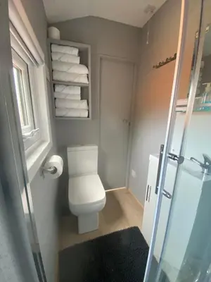 a small bathroom with a toilet and towels at The Beehive -Stunning Views - Hot Tub - Romantic in Launceston