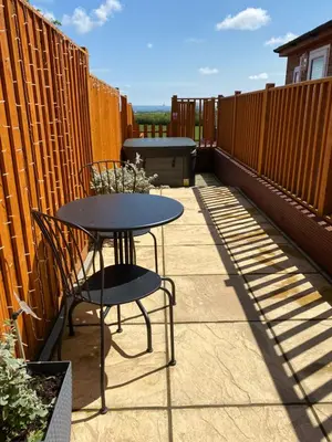 a patio with a table and chairs on a balcony at The Beehive -Stunning Views - Hot Tub - Romantic in Launceston