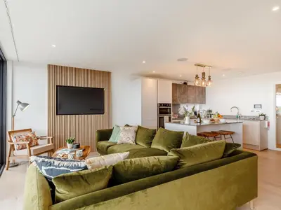 a living room with a green couch and a kitchen at Chi An Mor in Charlestown