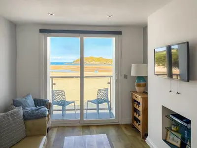 a living room with a view of the beach at Pennti Treth - Uk39455 in Saint Columb Minor