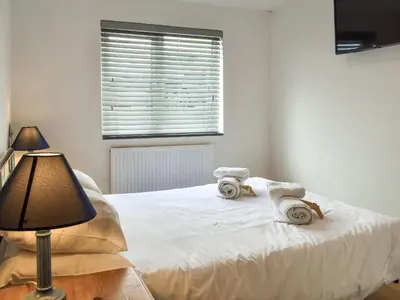 a bedroom with a white bed with towels and a lamp at Pennti Treth - Uk39455 in Saint Columb Minor