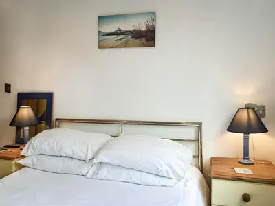 a bedroom with a bed with white sheets and two lamps at Pennti Treth - Uk39455 in Saint Columb Minor