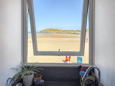 a view of the beach from a window at Pennti Treth - Uk39455 in Saint Columb Minor