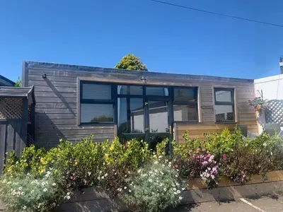 a house with a bunch of flowers in front of it at 1-bedroom chalet with parking on site in Looe